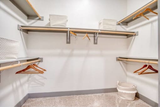a walk in closet with racks and a trash can at The Mark, San Antonio