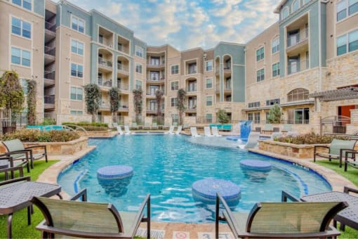 a swimming pool with an apartment building in the background at The Mark, San Antonio, TX 78230