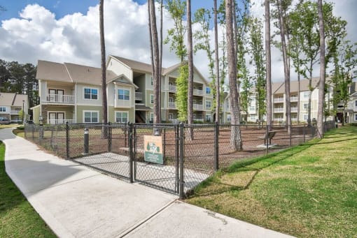 a fenced in dog park in front of an apartment building at Sterling Creek, Richmond Hill, GA
