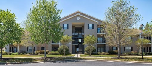 a large apartment building with trees in front of it at Mill Creek Run, Macon