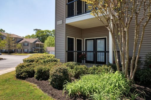 a building with a front door and a landscaped yard at Mill Creek Run, Macon, GA