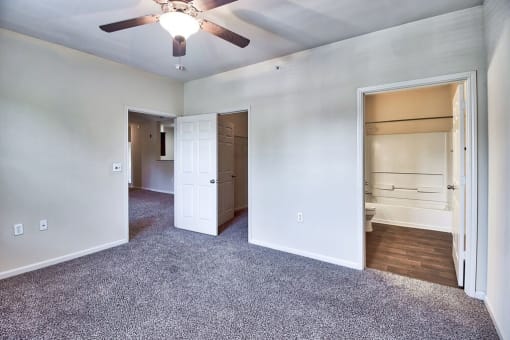 an empty living room with a ceiling fan and a closet at Mill Creek Run, Macon, GA 31216