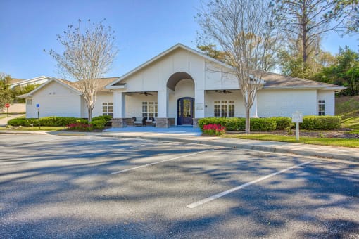 the front of a white building with a parking lot at Spring Creek Apartments, Crestview