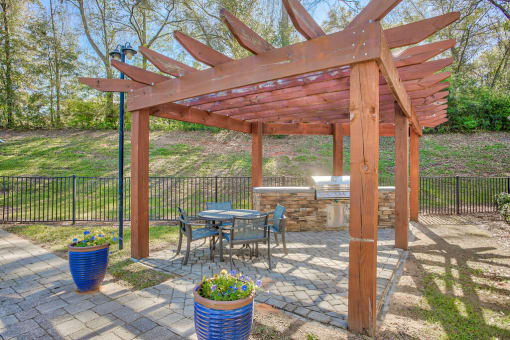 a patio with a table and chairs under a wooden pergola at Spring Creek Apartments, Crestview, FL 32536