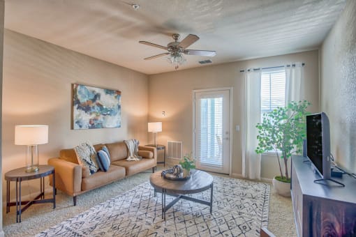 a living room with a couch and a ceiling fan at Spring Creek Apartments, Crestview, FL 32536