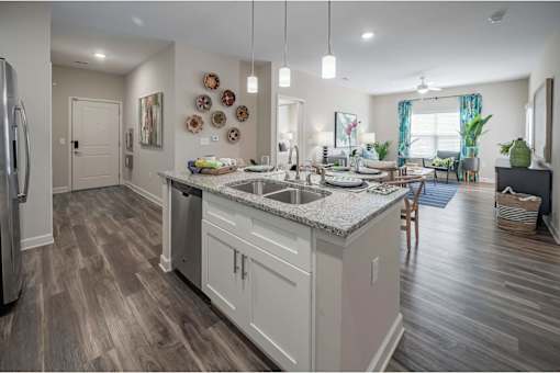 A kitchen with a white counter top and wooden cabinets at Waterleaf at Neely Ferry Apartments, Simpsonville