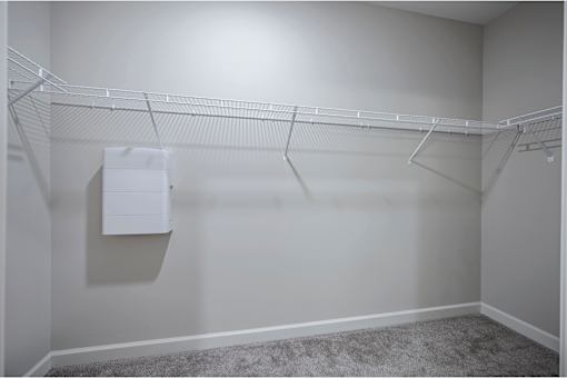 A white closet with a coat hanging on the rack at Waterleaf at Neely Ferry Apartments, Simpsonville, South Carolina