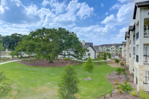 an aerial view of an apartment complex with a green lawn and trees at Legacy at Cibolo, Texas