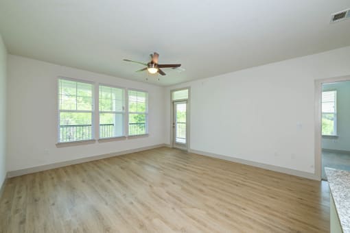 an empty living room with a ceiling fan and windows at Legacy at Cibolo, Boerne