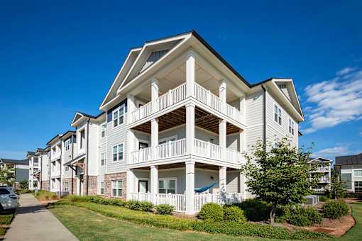 A white two-story apartment building with a balcony on the second floor at Waterleaf at Neely Ferry Apartments, South Carolina
