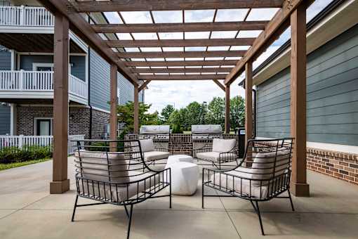 Two chairs and a table are on a patio at Waterleaf at Neely Ferry Apartments, South Carolina