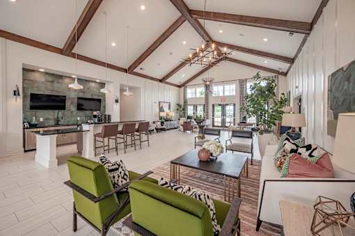 A modern living room with a stone fireplace and a large open space at Waterleaf at Neely Ferry Apartments, Simpsonville, South Carolina