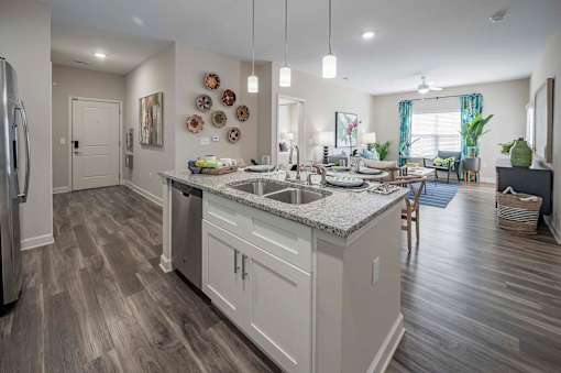 A modern kitchen with a large island and wooden floors at Waterleaf at Neely Ferry Apartments, South Carolina