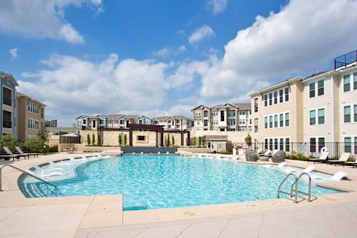 A large swimming pool in front of apartment buildings.
