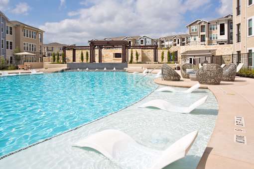 A pool with a white fountain in the middle of it.
