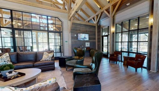 a large living room with leather furniture and large windows at Bellary Flats Apartments, Summerville , SC 29486