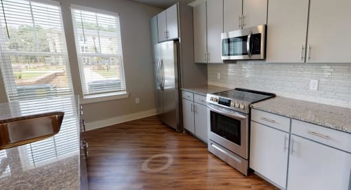 a kitchen with stainless steel appliances and white cabinets at Bellary Flats Apartments, Summerville , SC