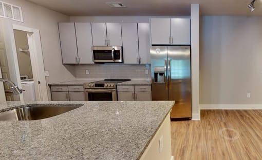 a kitchen with granite counter tops and stainless steel appliances at Bellary Flats Apartments, Summerville