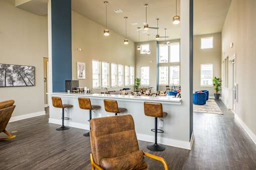 A room with a bar and chairs.