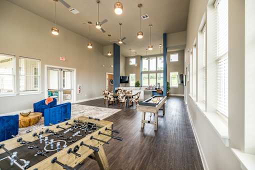 A room with a foosball table in the middle of it.