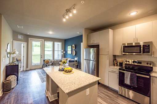 A kitchen with a refrigerator, oven, and microwave.