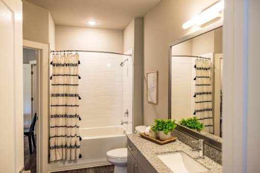 A bathroom with a white toilet, a sink, and a mirror.