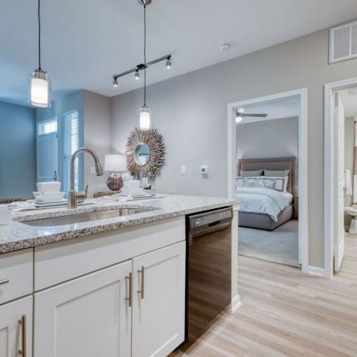 a white kitchen with a sink and a bedroom at Citadel at Westpointe, San Antonio, Texas