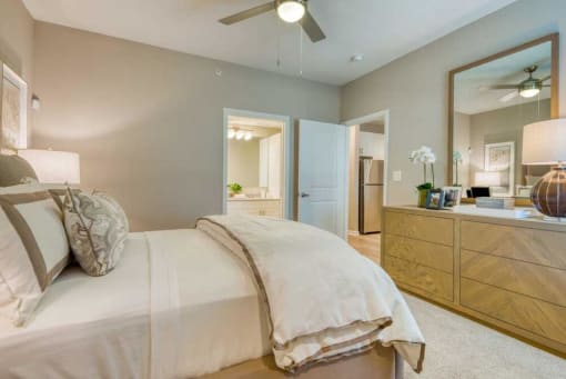 a bedroom with a cozy bed and a mirror at Citadel at Westpointe, Texas, 78251