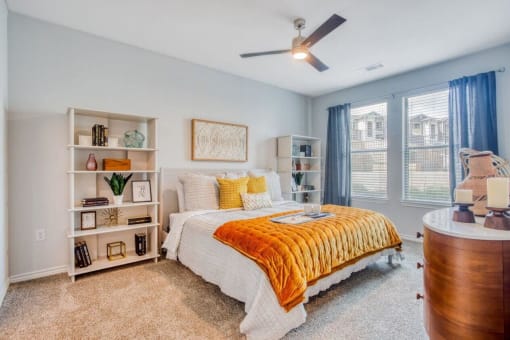a bedroom with a bed and a ceiling fan  at Edge and Stone, San Antonio, 78260