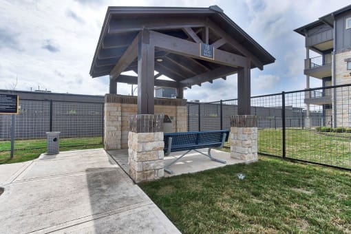 a picnic area with a bench in front of a fence at Legacy Flats, San Antonio, 78254