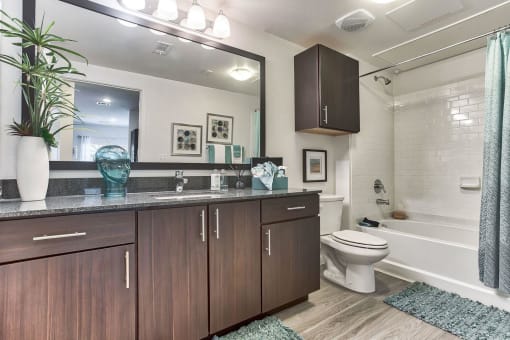 a bathroom with wooden cabinets and a toilet and a sink at Legacy Flats, Texas, 78254