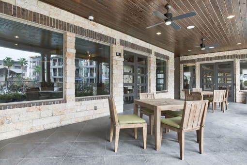 a covered patio with a wooden table and chairs at Legacy Flats, San Antonio