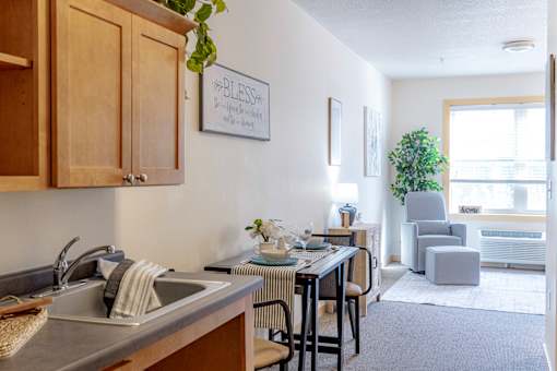 an open kitchen and living room with a dining room table and chairs and a window