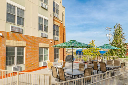 our apartments have a patio with tables and chairs and umbrellas