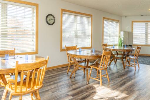 a dining room with tables and chairs and a clock on the wall