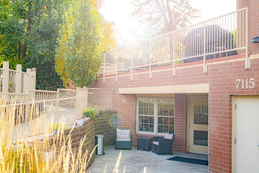 a brick building with a balcony and a patio with furniture