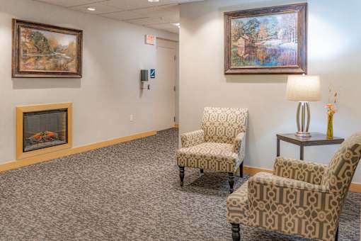 a waiting room with two chairs and a fireplace