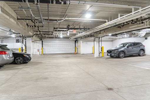 a parking garage with two cars parked in it