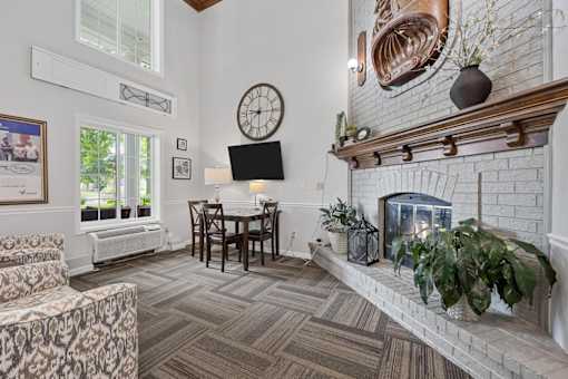 A living room with a fireplace and a clock on the wall.