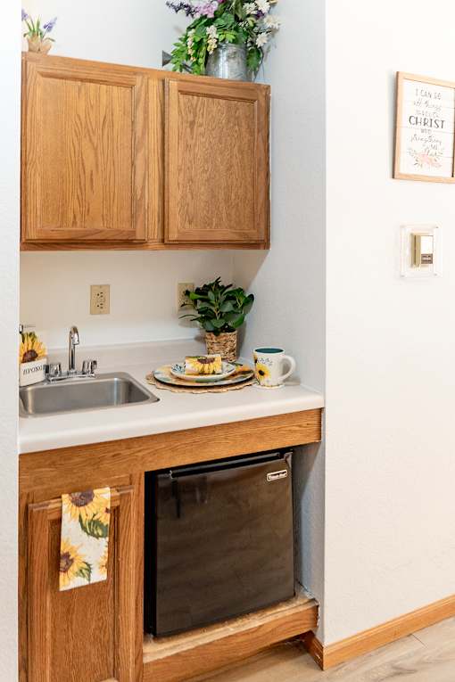 A kitchen with wooden cabinets and a fridge.