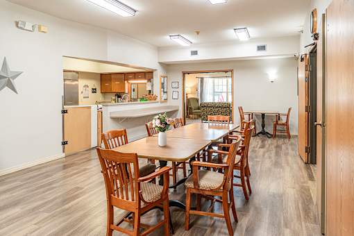 A dining room with a table and chairs.