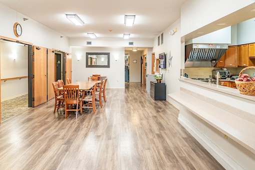 A kitchen with a dining table and chairs in the middle of the room.