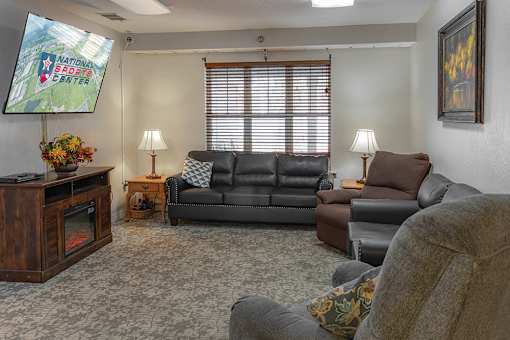 A living room with a flat screen TV and a couch.