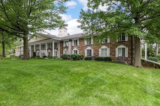 A large house with a green lawn in front.