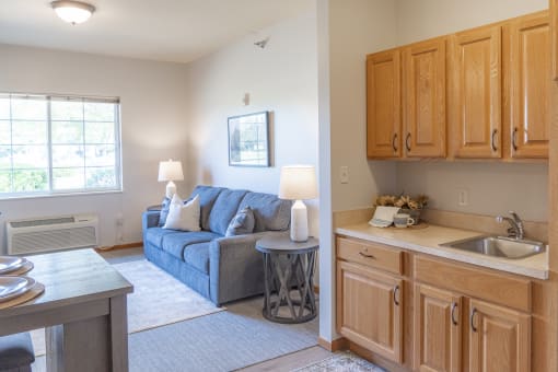 a living room with a couch and a kitchen with a sink
