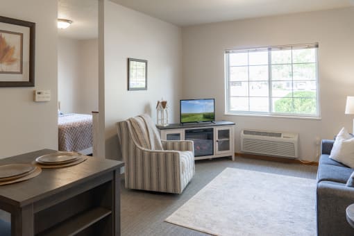 a living room with a couch and a chair and a tv