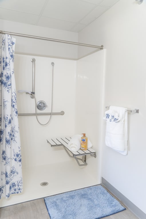 a small bathroom with a shower and a blue and white shower curtain