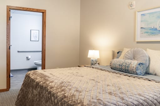 a bedroom with a bed and a door to a bathroom