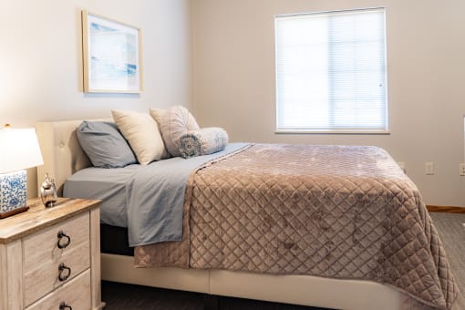 a bedroom with a bed and two windows