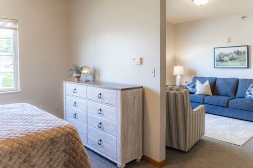 a bedroom with a couch and a bed and a dresser